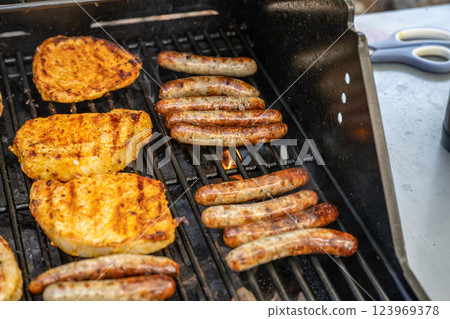Barbecue grill bbq on propane gas grill steaks bratwurst sausages meat meal 123969378