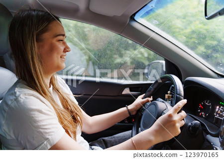 A young girl is driving a car. an inexperienced driver. A young girl is driving a car. an inexperienced driver. 123970165