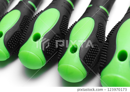 green plastic screwdriver handles on a white background.  123970173