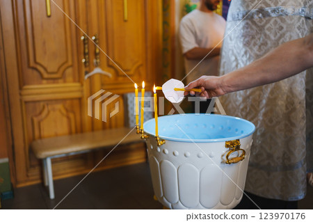 Three lit church candles on the baptismal font in a wooden church. Three lit church candles on the baptismal font in a wooden church. 123970176