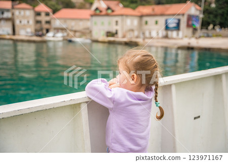 Little girl traveling with family by ferry. Crossing from one bank to another of Kotor bay in Montenegro 123971167