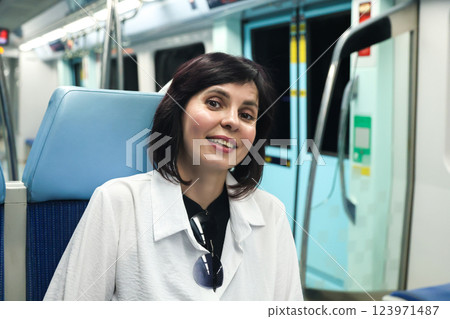 A Thoughtful Brunette Woman Sits in a Subway Car, Observing Her Surroundings with Curiosity and Contemplation, Capturing the Essence of Urban Life and the Unique Stories of Fellow Passengers in the A Thoughtful Brunette Woman Sits in a Subway Car, Observing Her Surroundings with Curiosity and Contemplation, Capturing the Essence of Urban Life and the Unique Stories of Fellow Passengers in the 123971487