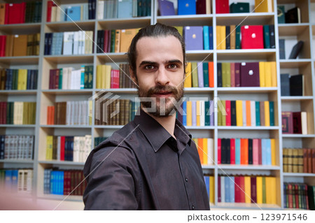 Selfie photo portrait young 30s positive man inside library Selfie photo portrait young 30s positive man inside library 123971546