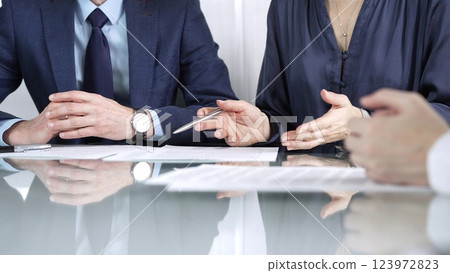Business partners or lawyers are discussing contract papers during a meeting, negotiating and making decisions together. Business people concept, close up 123972823