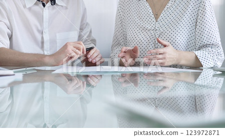 Business colleagues reviewing a contract, engaging in negotiations and strategic decision making in a professional office setting, white casual dress style. Business people concept Business colleagues reviewing a contract, engaging in negotiations and strategic decision making in a professional office setting, white casual dress style. Business people concept 123972871