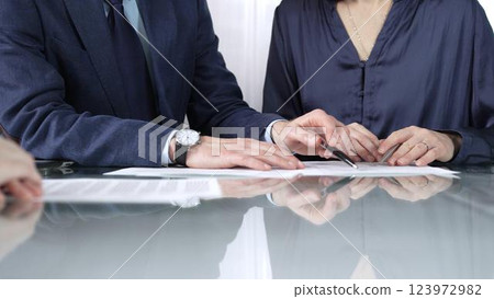Business people reviewing contract terms during a meeting, negotiating and making decisions together. Business people concept, close up 123972982