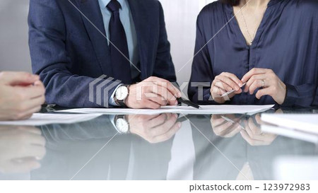 Business people reviewing contract terms during a meeting, negotiating and making decisions together. Business people concept, close up 123972983