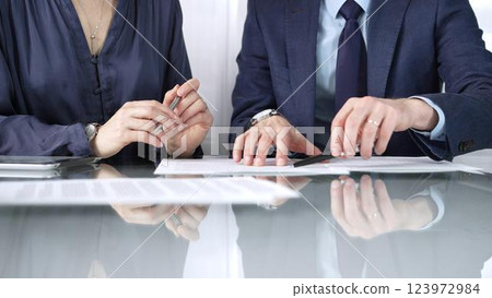 Business partners or lawyers are reviewing contract terms during a meeting, negotiating and making decisions together. Business people concept, close up view Business partners or lawyers are reviewing contract terms during a meeting, negotiating and making decisions together. Business people concept, close up view 123972984