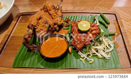 Traditional Ayam Taliwang indonesian cuisine with Vegetable Mash and Curry Soup on Banana Leaf 123973684