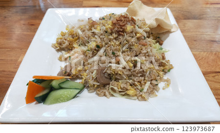 Savory Seafood Fried Rice on White Plate with Wooden Table Background Savory Seafood Fried Rice on White Plate with Wooden Table Background 123973687