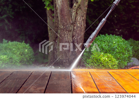 cleaning terrace with a power washer - high water pressure cleaner on wooden terrace surface cleaning terrace with a power washer - high water pressure cleaner on wooden terrace surface 123974044