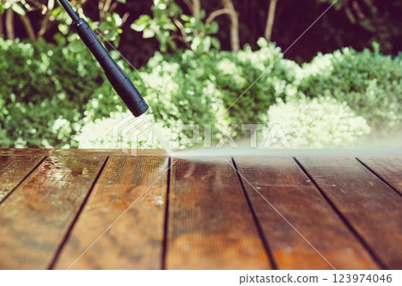 cleaning terrace with a power washer - high water pressure cleaner on wooden terrace surface 123974046