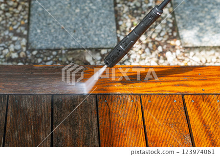 cleaning terrace with a power washer - high water pressure cleaner on wooden terrace surface 123974061