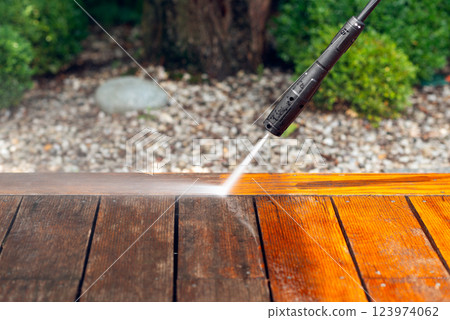 cleaning terrace with a power washer - high water pressure cleaner on wooden terrace surface 123974062