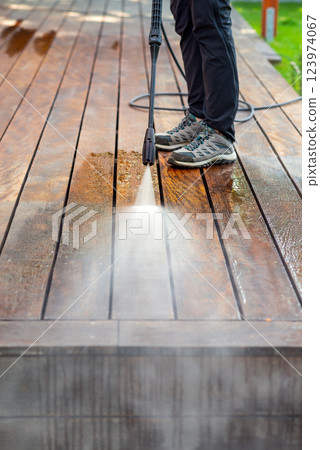 cleaning terrace with a power washer - high water pressure cleaner on wooden terrace surface cleaning terrace with a power washer - high water pressure cleaner on wooden terrace surface 123974067
