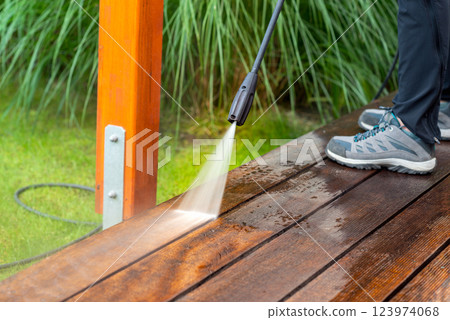 cleaning terrace with a power washer - high water pressure cleaner on wooden terrace surface 123974068