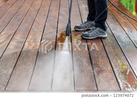 cleaning terrace with a power washer - high water pressure cleaner on wooden terrace surface 123974072