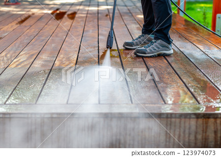 cleaning terrace with a power washer - high water pressure cleaner on wooden terrace surface 123974073