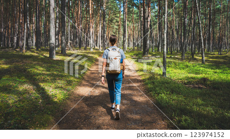 Young woman with backpack hiking in the forest. Hiking concept. 123974152