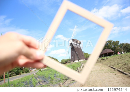 Hand pointing at a windmill 123974244