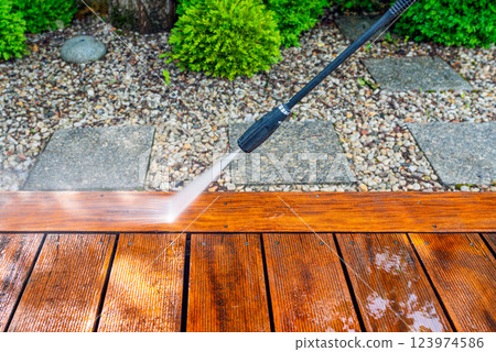 cleaning terrace with a power washer - high water pressure cleaner on wooden terrace surface cleaning terrace with a power washer - high water pressure cleaner on wooden terrace surface 123974586