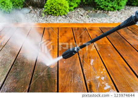 cleaning terrace with a power washer - high water pressure cleaner on wooden terrace surface 123974644