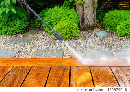 cleaning terrace with a power washer - high water pressure cleaner on wooden terrace surface 123974648