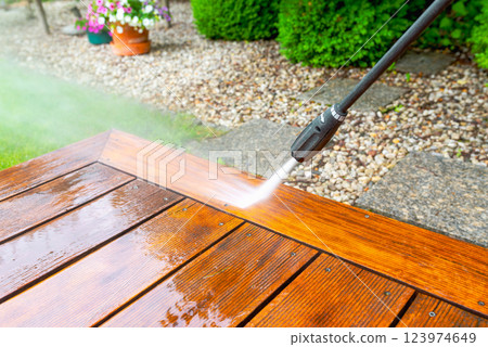 cleaning terrace with a power washer - high water pressure cleaner on wooden terrace surface cleaning terrace with a power washer - high water pressure cleaner on wooden terrace surface 123974649