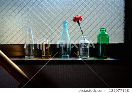 "The tranquil beauty of empty bottles bathed in sunlight by a window 123977138