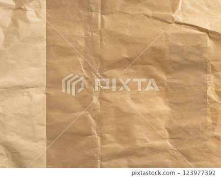 Old, wrinkled kraft paper texture in beige and brown tones. Creased and crumpled surface with a Old, wrinkled kraft paper texture in beige and brown tones. Creased and crumpled surface with a 123977392