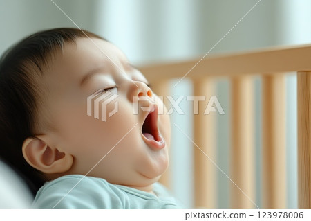 Quiet, peaceful nursery with a yawning newborn baby in the crib Quiet, peaceful nursery with a yawning newborn baby in the crib 123978006