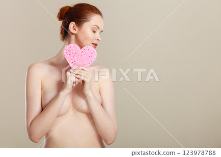 Naked woman holding pink heart sponge in hands. Naked woman holding pink heart sponge in hands. 123978788