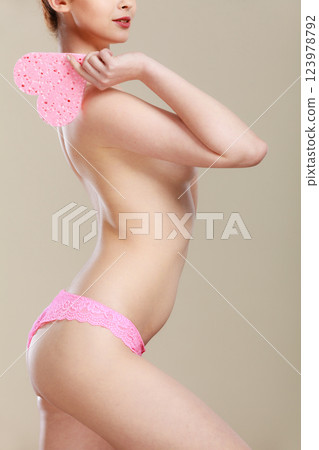Naked woman holding pink heart sponge in hands. 123978792