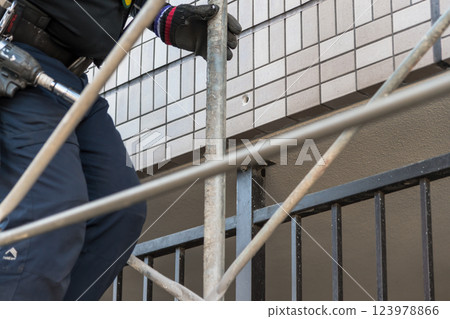 [Workers building scaffolding during large-scale apartment repair work] 123978866