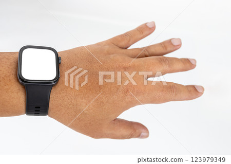 A chubby Asian man with yellow skin wearing a black smartwatch on his wrist and spreading his fingers with a white screen. 123979349