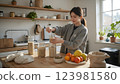 Woman arranging eco friendly products kitchen at home, eco friendly lifestyle choosing sustainable items consciously, natural minimalist interior promoting eco friendly choices daily modern routine. 123981580