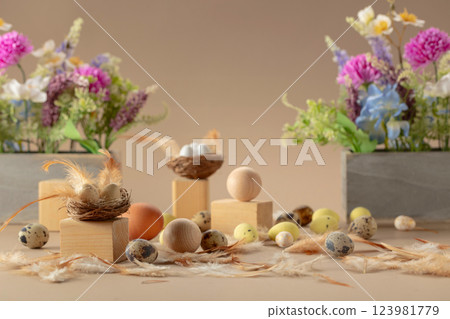 Easter composition with eggs, feathers, and spring flowers on a beige background. 123981779