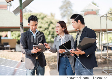 Sustainable business initiative. Professionals analyzing solar energy data outdoors. 123981850