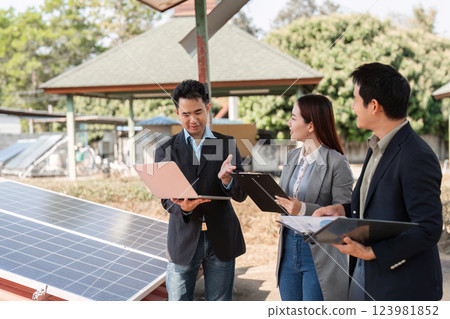 Teamwork in sustainability. Professionals reviewing solar panel effectiveness and business strategies. 123981852