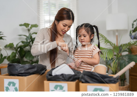 Recycling and Family Education. A mother guides her daughter through an important life lesson about sustainability. 123981889