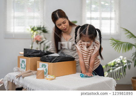 Eco-Friendly Practices and Family Bonding. A mother and daughter engaging in recycling activities for a better planet. Eco-Friendly Practices and Family Bonding. A mother and daughter engaging in recycling activities for a better planet. 123981893