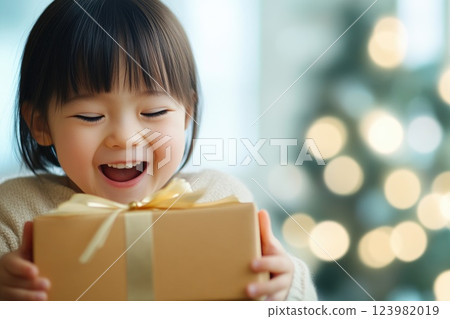 Joyful child unwrapping surprise present Joyful child unwrapping surprise present 123982019
