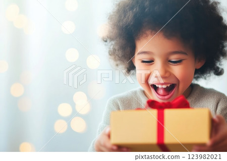 Child unwraps a surprise gift box Child unwraps a surprise gift box 123982021