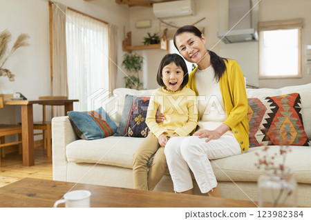 Grandmother spending time with her grandchild in the living room 123982384