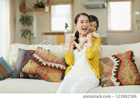 Grandmother spending time with her grandchild in the living room 123982386