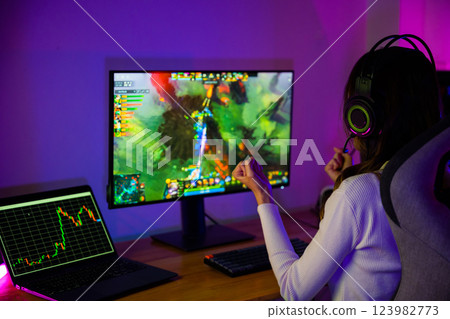 Asian gamer playing online video game excited on desktop computer PC display neon LED lights, woman in gaming headphones use computer happy successful, Winning possibly celebrating victory, E-Sport 123982773