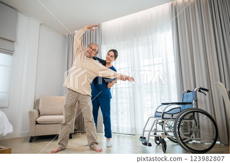 Old senior man enjoys training with physiotherapist for outstretched arms at home, Asian physical therapist patient nursing helping elderly exercising arm stretch, Rehabilitation of disabled concept Old senior man enjoys training with physiotherapist for outstretched arms at home, Asian physical therapist patient nursing helping elderly exercising arm stretch, Rehabilitation of disabled concept 123982807