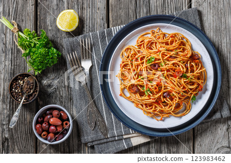 vegan whole grain pasta alla puttanesca on a plate vegan whole grain pasta alla puttanesca on a plate 123983462
