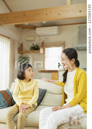 Grandmother spending time with her grandchild in the living room 123984195