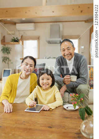 Grandparents watching their grandchildren studying on a tablet 123984222